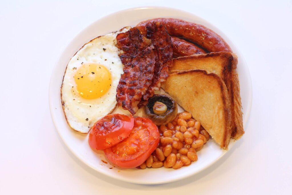 Anglická snídaně, slanina, klobása, fazole, žampióny, vejce, grilované rajče